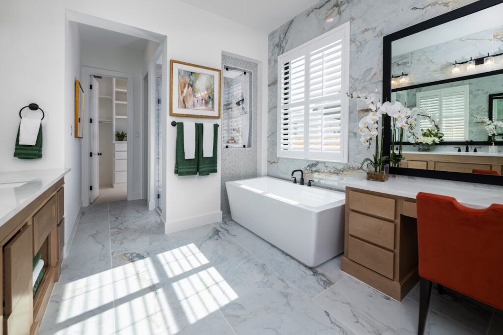 A luxurious marble bathroom showing how to clean a bathroom floor and tub area.