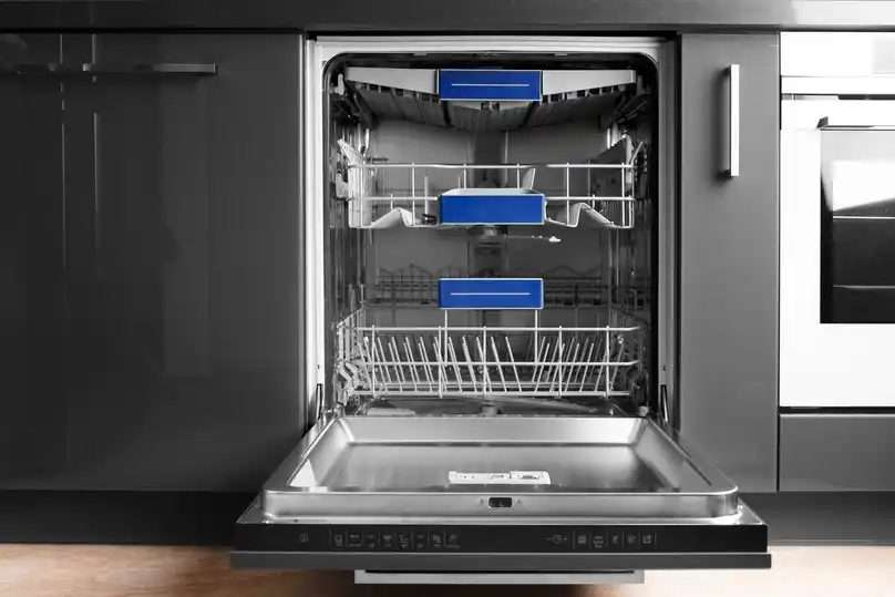 An open, empty dishwasher in a modern kitchen, showing how to clean a dishwasher.