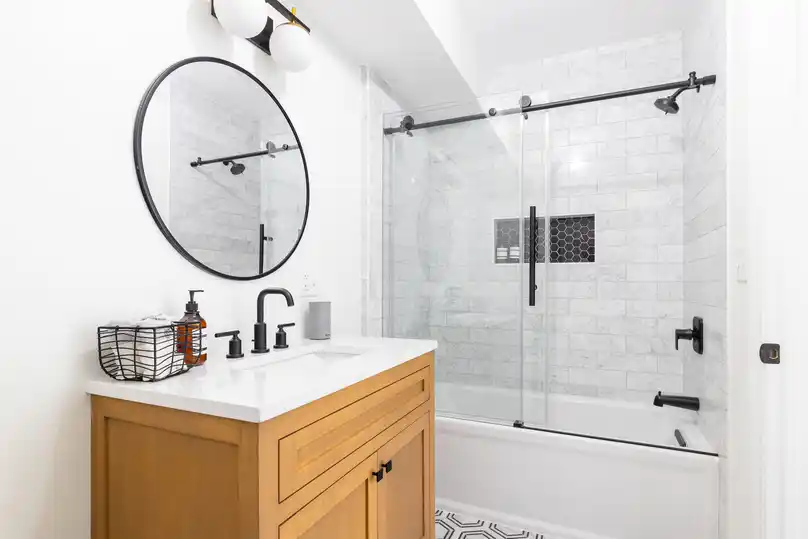 Modern bathroom with clear glass shower doors, showcasing how to clean shower glass effectively.