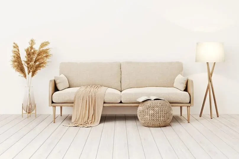 A minimalist beige couch in a clean living room, ideal for learning how to clean sofa fabric.