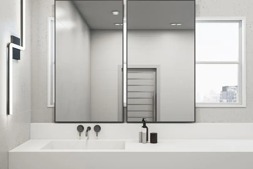 bathroom with white sink and two large mirrors, ideal for illustrating how to clean mirror surfaces