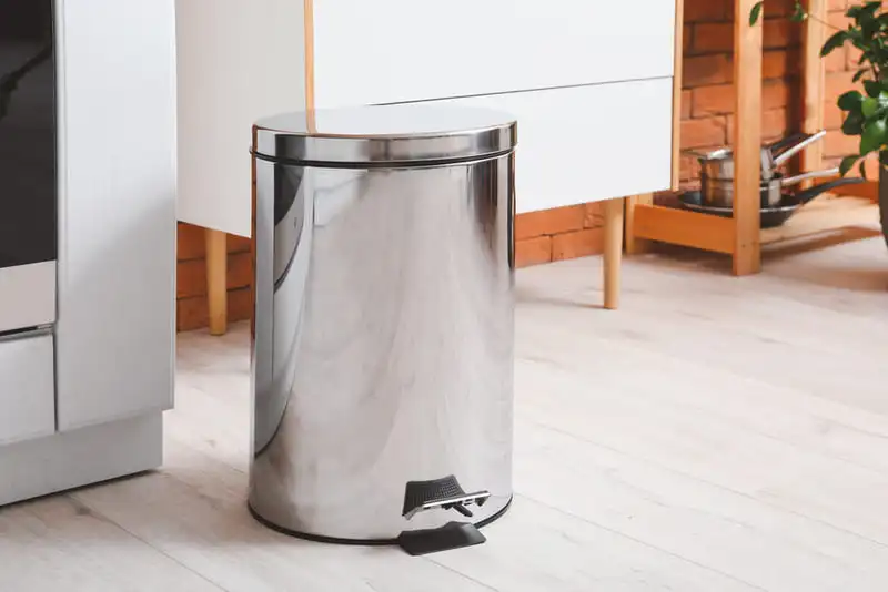 A shiny stainless steel bin in a kitchen, demonstrating how to clean trash can surfaces.