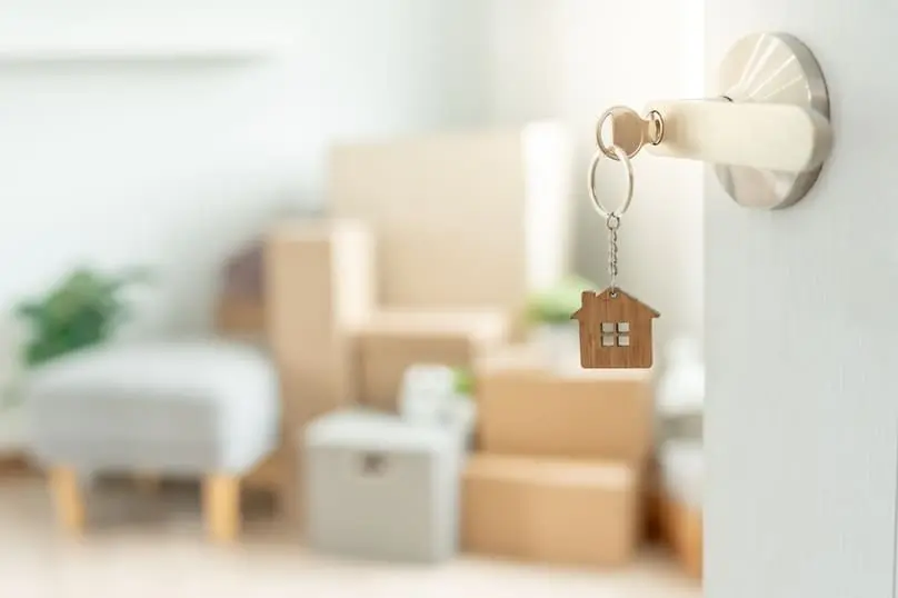New home keys on a door, highlighting the importance of a new homeowner checklist.