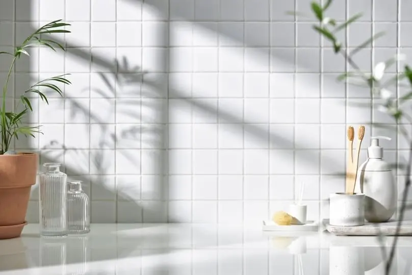 A clean bathroom with white tiled walls and a countertop, suggesting how to clean grout in shower