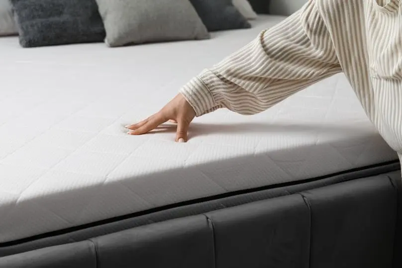 Person checking mattress surface after following tips on how to get stains off a mattress.