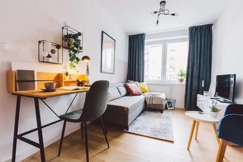 A well-organized small living room with a desk area, perfect for organizing tips for small spaces.