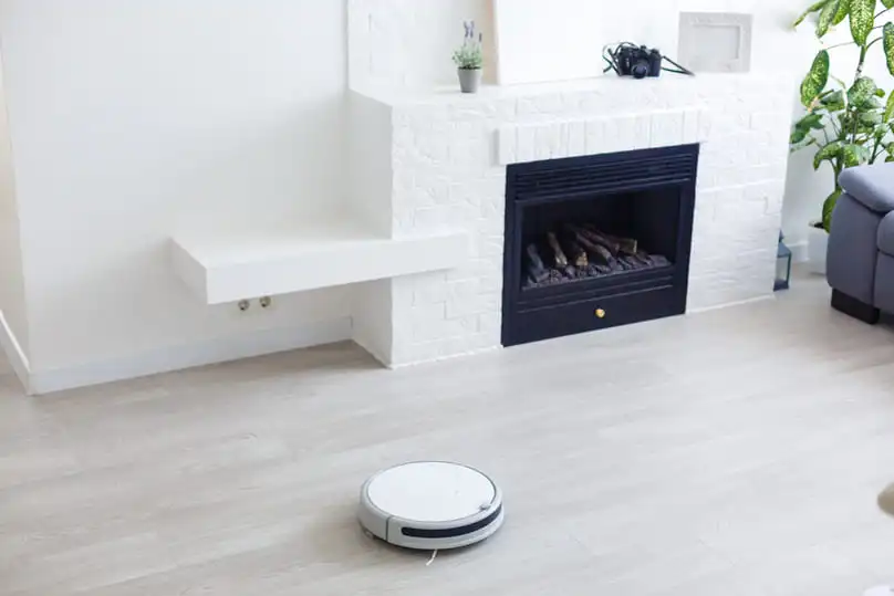 A robotic vacuum on a hardwood floor, a great example of AI-powered cleaning.
