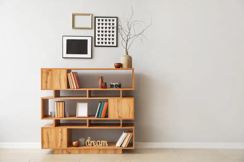 A modern wooden bookshelf with books and decor, perfect for learning how to clean wooden shelves.