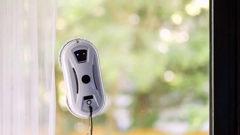A robotic window cleaner on a glass pane, a type of window cleaning robot.