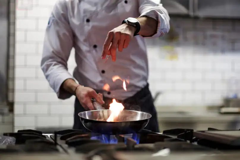 Clean stainless steel cookware on a dark surface, showing how to clean a burnt pan or pot.